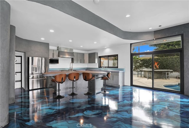 205 Esplanade, San Clemente, CA 92672 - kitchen with modern cabinets, a breakfast bar area, wall chimney range hood, gray cabinetry, and stainless steel appliances