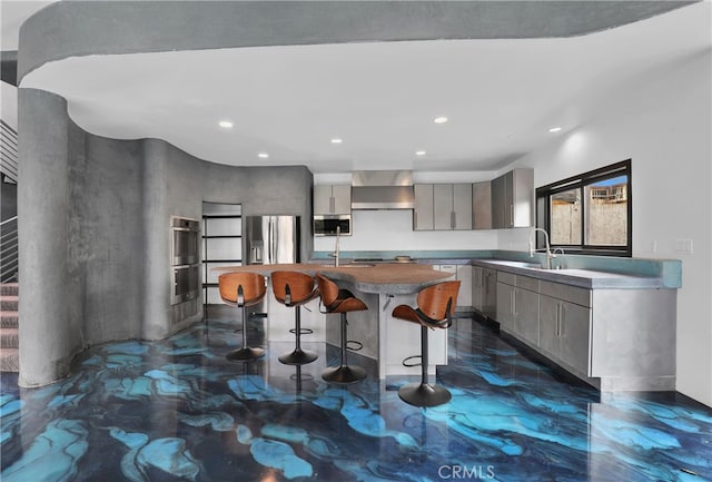 205 Esplanade, San Clemente, CA 92672 - kitchen featuring appliances with stainless steel finishes, an island with sink, gray cabinets, a kitchen bar, and modern cabinets