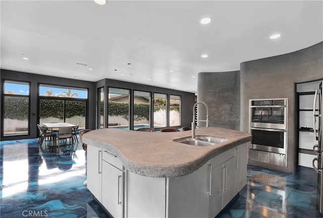 205 Esplanade, San Clemente, CA 92672 - kitchen featuring a sink, recessed lighting, white cabinetry, and an island with sink