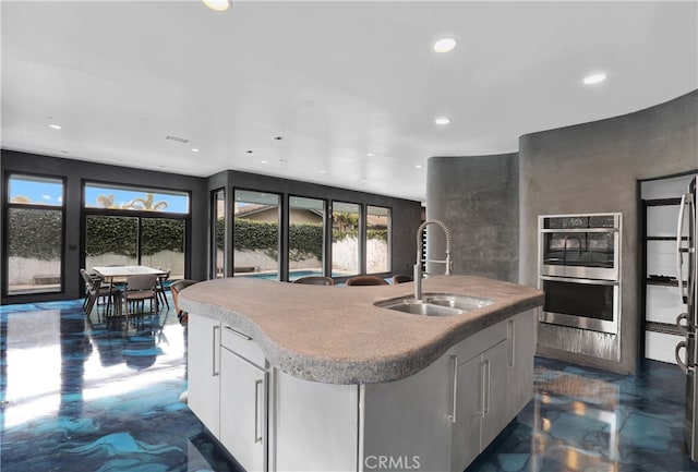205 Esplanade, San Clemente, CA 92672 - kitchen with recessed lighting, double oven, an island with sink, and white cabinets
