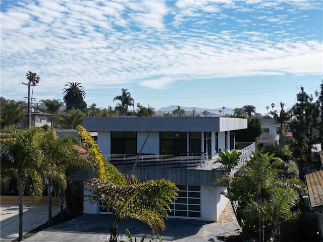 view of front of home with driveway, an attached garage, and stucco siding