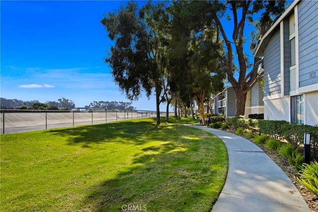 view of community featuring fence and a lawn