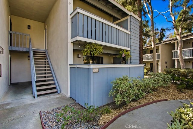 view of property exterior with stairway and stucco siding