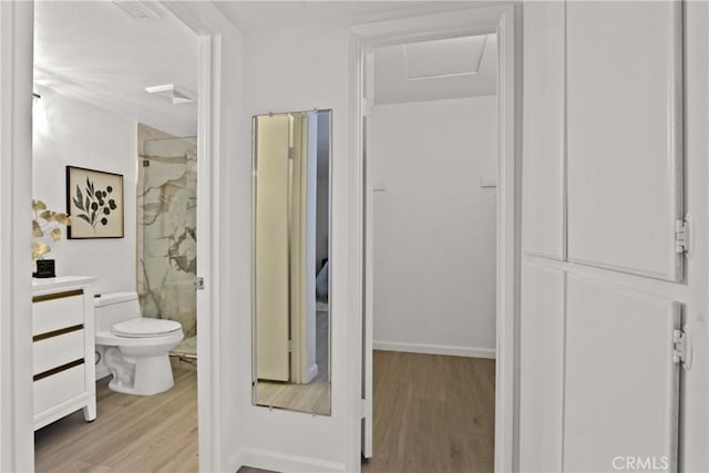 full bath featuring a marble finish shower, visible vents, toilet, vanity, and wood finished floors