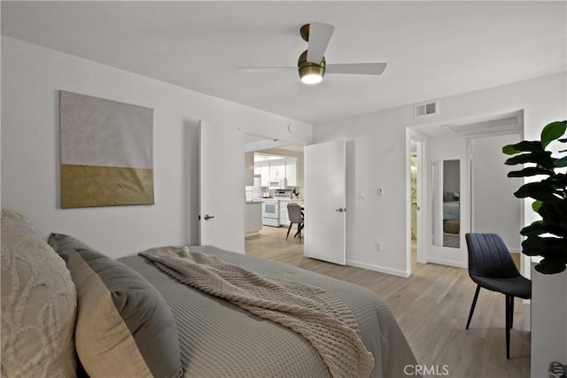 bedroom with a ceiling fan, light wood-style flooring, visible vents, and baseboards