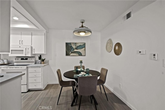 dining space with light wood-type flooring, baseboards, and visible vents