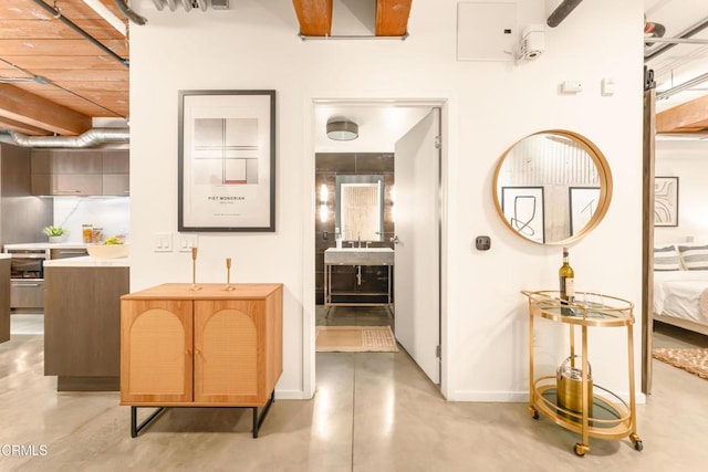 hall featuring baseboards and finished concrete floors