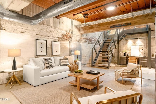 living area featuring stairs, visible vents, and concrete flooring