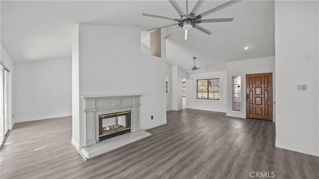 unfurnished living room with ceiling fan, high vaulted ceiling, dark wood-style flooring, baseboards, and a glass covered fireplace