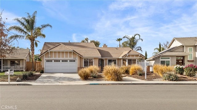 view of front of home featuring an attached garage, a tile roof, fence, driveway, and a chimney