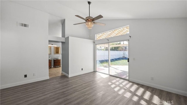 unfurnished living room featuring a towering ceiling, baseboards, visible vents, and dark wood-style flooring