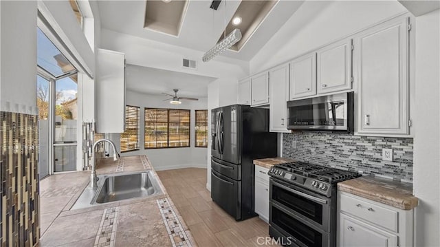 kitchen with visible vents, stainless steel appliances, light countertops, white cabinetry, and a sink