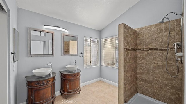 full bath with lofted ceiling, two vanities, a sink, and a shower stall