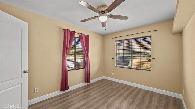 unfurnished room featuring light wood finished floors, a ceiling fan, and baseboards