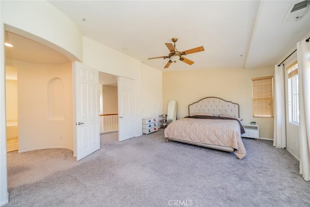 bedroom featuring light carpet, ceiling fan, arched walkways, and visible vents