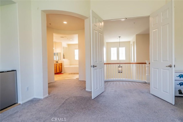 interior space featuring light carpet and arched walkways