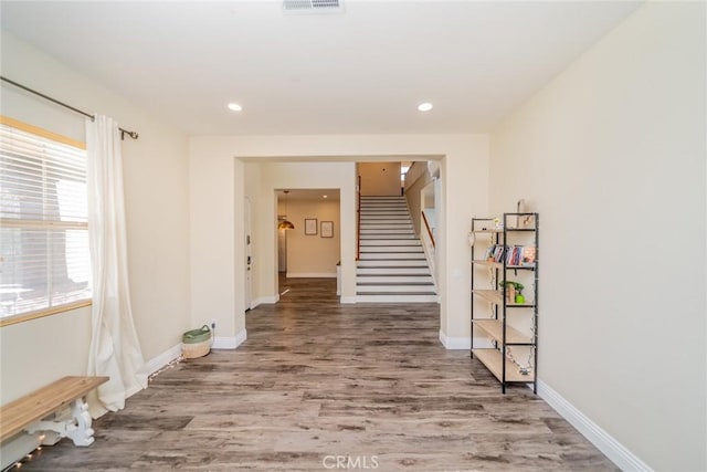 hall featuring baseboards, stairway, wood finished floors, and recessed lighting