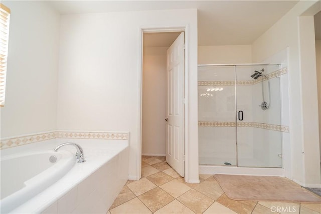 bathroom featuring a stall shower, tile patterned flooring, and a garden tub