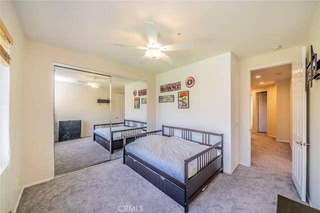 bedroom with ceiling fan, baseboards, a closet, and light colored carpet