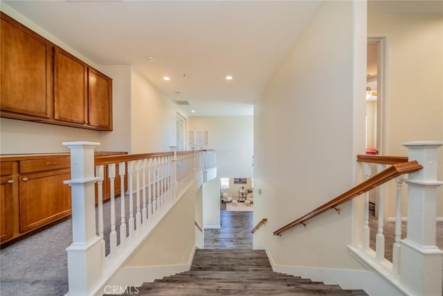 stairway featuring baseboards, wood finished floors, and recessed lighting