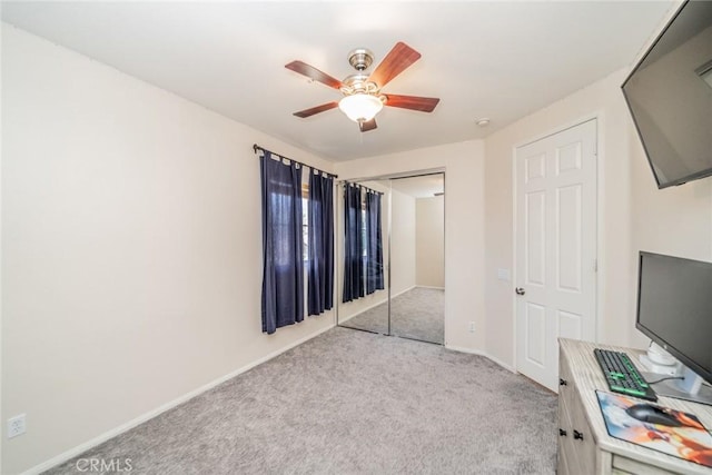 unfurnished bedroom featuring a closet, light colored carpet, ceiling fan, and baseboards