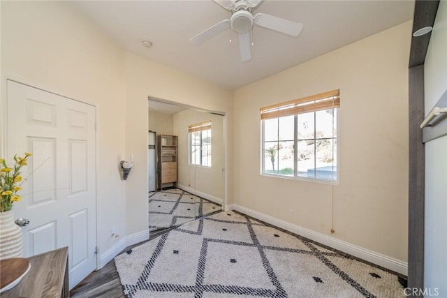 interior space with a ceiling fan and baseboards