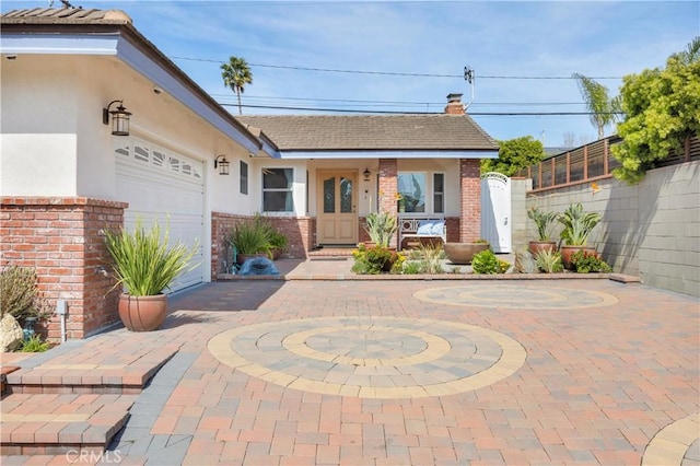 view of front of home featuring brick siding, fence, and stucco siding