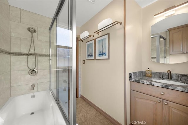 bathroom featuring shower / bath combination with glass door, tile patterned flooring, baseboards, and vanity