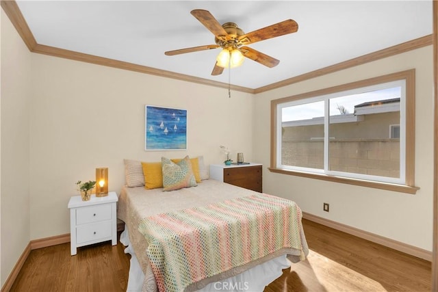 bedroom featuring crown molding, baseboards, and wood finished floors