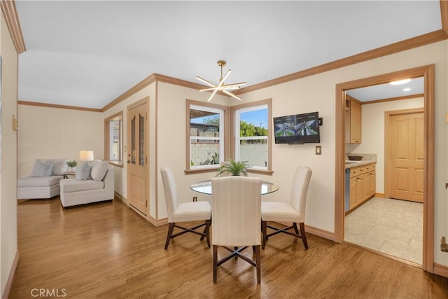 dining area with a notable chandelier, ornamental molding, baseboards, and light wood-style floors