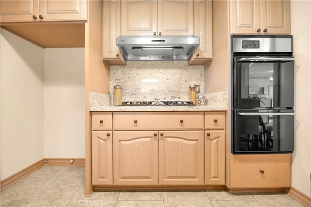 kitchen featuring dobule oven black, under cabinet range hood, baseboards, decorative backsplash, and stainless steel gas stovetop