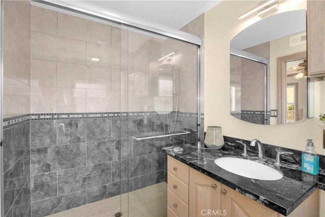 full bath with a stall shower, visible vents, and vanity