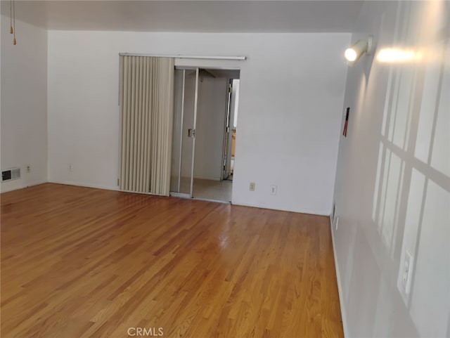 unfurnished room featuring light wood-style flooring and visible vents