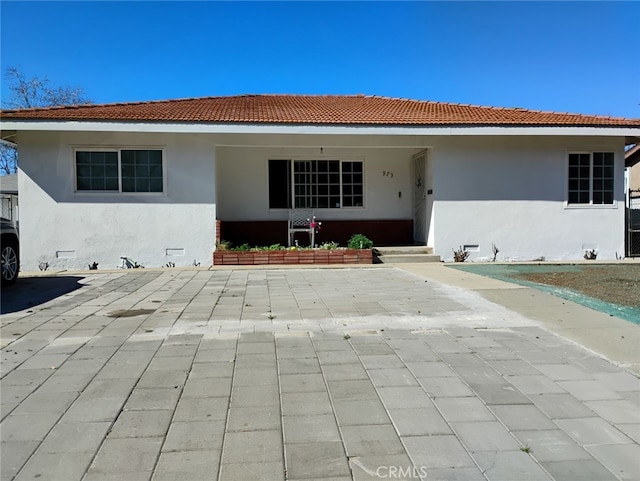 ranch-style home with crawl space, a tile roof, a patio, and stucco siding