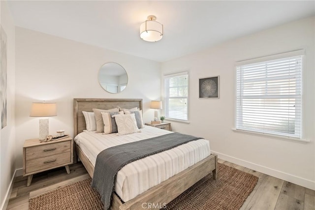 bedroom with light wood-style flooring and baseboards