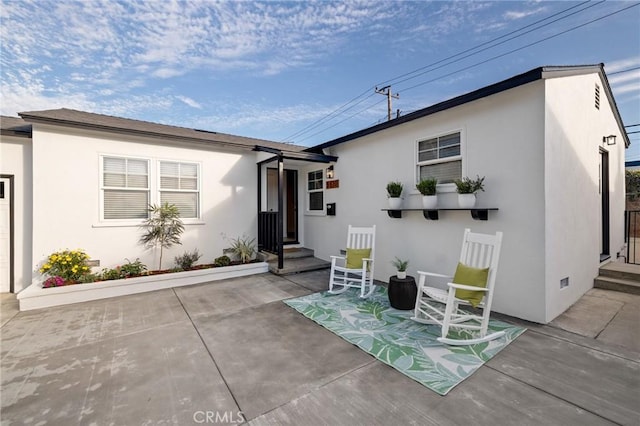 back of house with a patio area and stucco siding