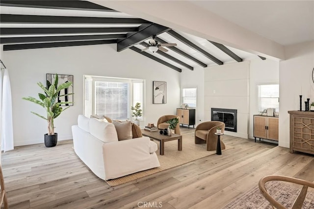 living area with a wealth of natural light, a fireplace, light wood finished floors, and ceiling fan