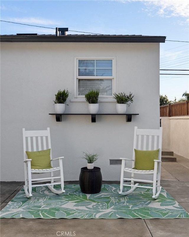 back of property featuring a patio area, fence, and stucco siding