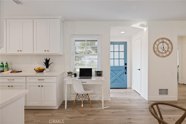 office area featuring baseboards, visible vents, and light wood finished floors