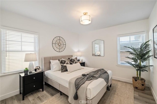 bedroom featuring light wood-type flooring and baseboards