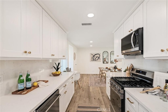 kitchen featuring visible vents, white cabinetry, light countertops, appliances with stainless steel finishes, and light wood-type flooring