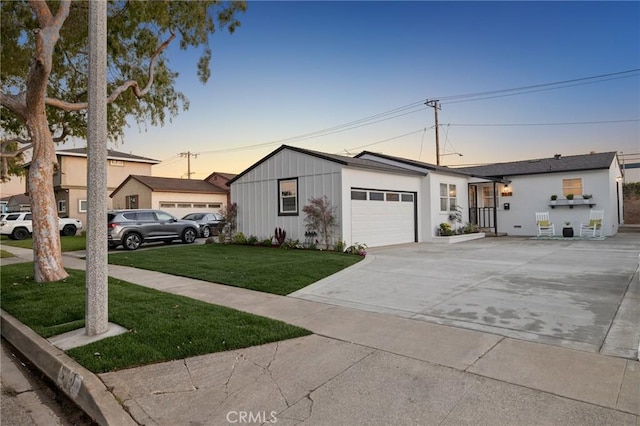 view of front facade with a garage, a front yard, driveway, and board and batten siding