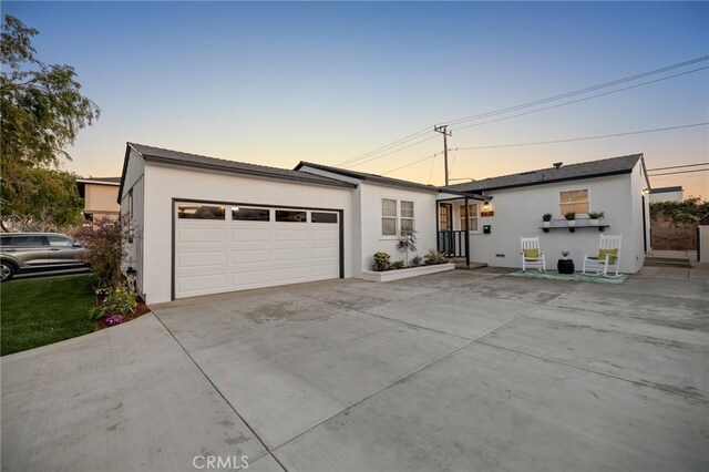 view of front of property featuring an attached garage, concrete driveway, and stucco siding