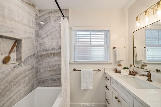 full bath featuring a healthy amount of sunlight, shower / bathtub combination with curtain, and vanity