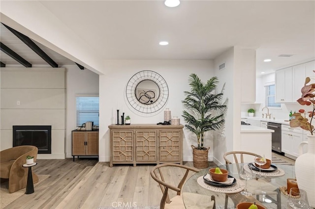 sitting room with visible vents, beamed ceiling, light wood-style floors, a fireplace, and recessed lighting