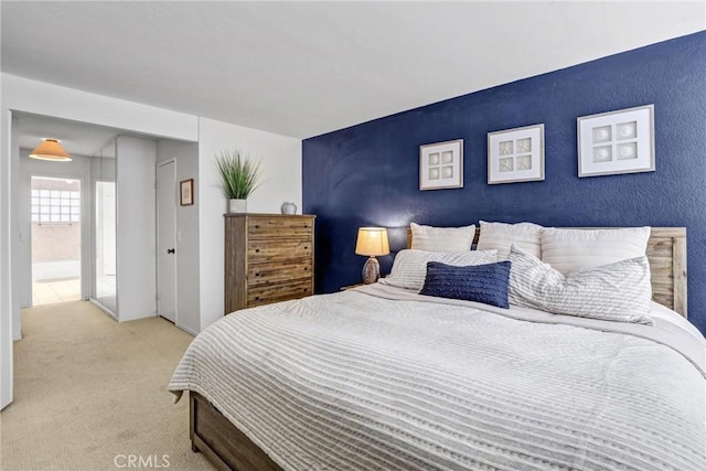 bedroom with carpet and an accent wall