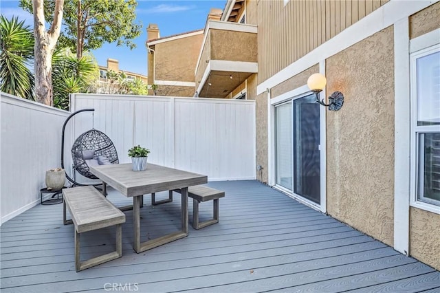 deck featuring outdoor dining area and fence