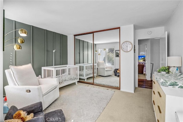 bedroom with light carpet and a closet