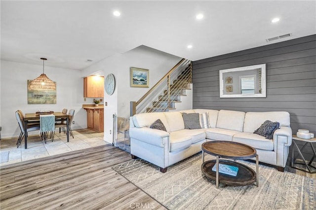 living room featuring light wood finished floors, stairs, visible vents, and recessed lighting