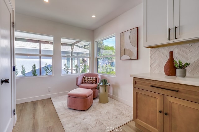 living area featuring recessed lighting, light wood finished floors, and baseboards